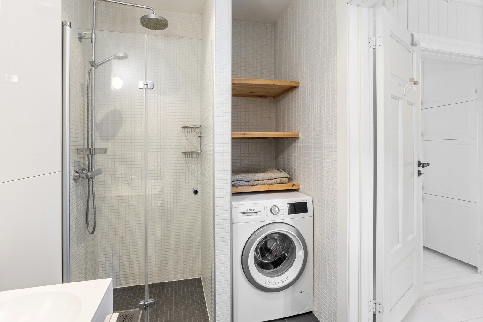 Opplegg for vaskemaskin i egen nisje med hyller over. Galleribilde