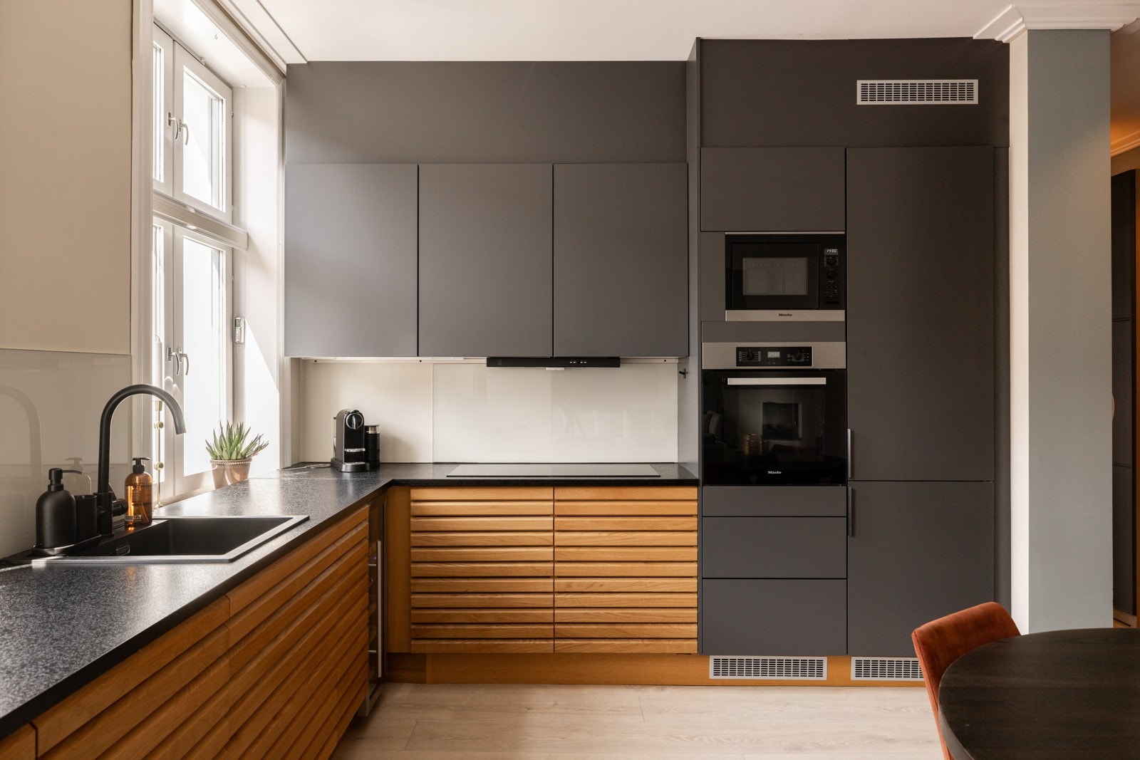 Flott HTH innredning med takhøye overskap og underskap med spiler i tre, benkeplate av laminat, nedfelt oppvaskkum med ett-greps kjøkkenarmatur, i tillegg til belysning over kjøkkenbenk og stikkontakt nedfelt i kjøkkenbenk. Galleribilde