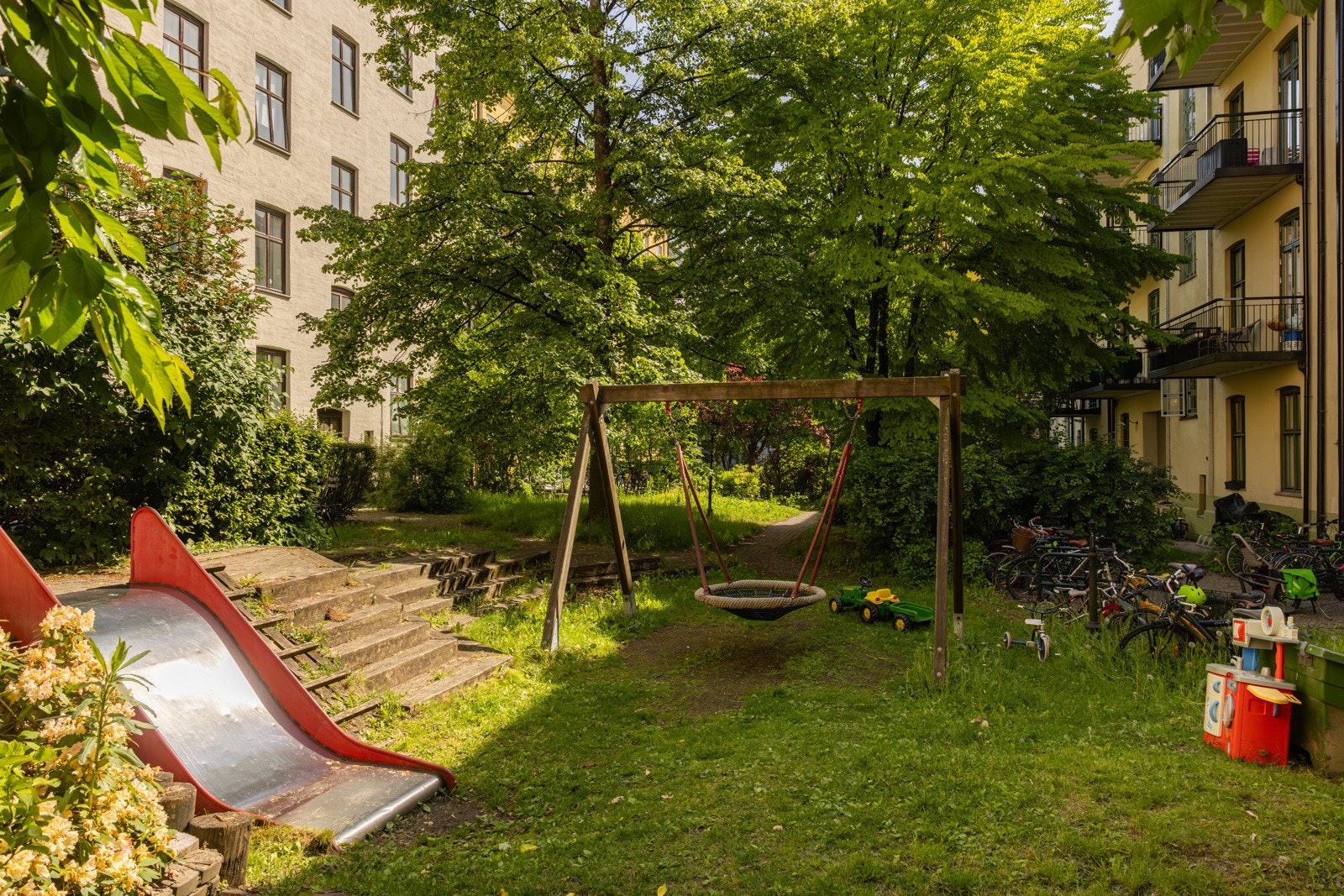 Flotte, frodige fellesarealer med grønne plener, sittegrupper og lekeapparater for de minste. Galleribilde