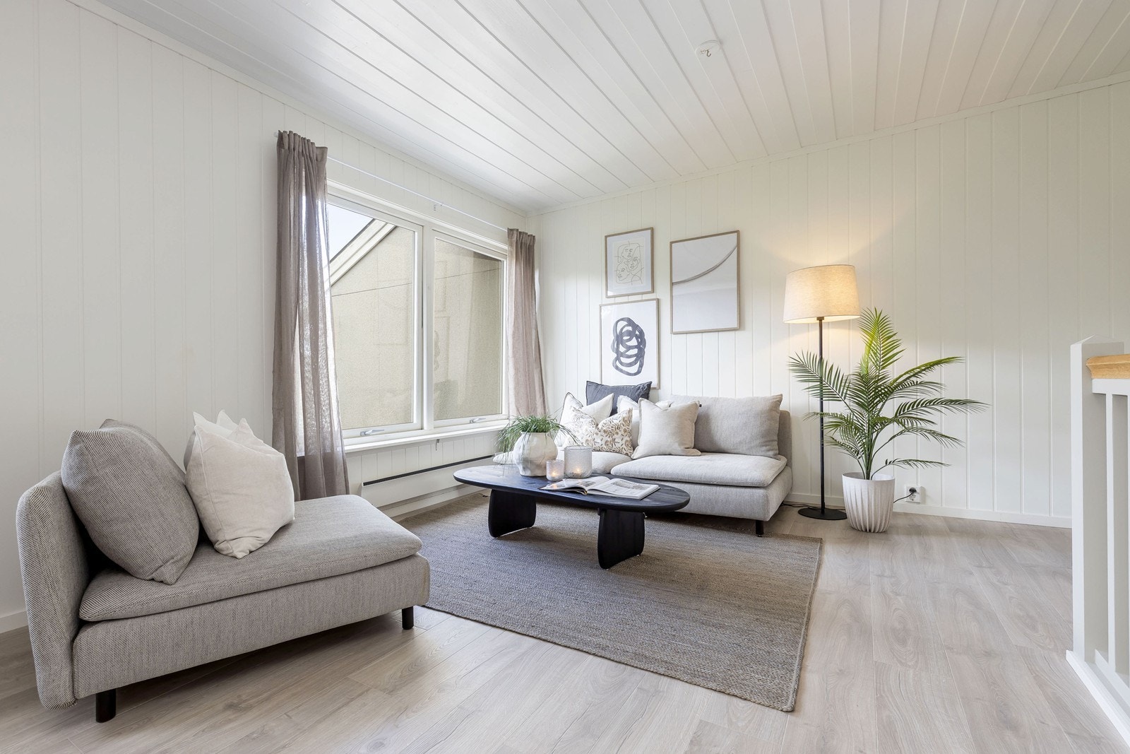Fra 1. etasje kommer du opp til en lys, åpen stue med moderne lyse overflater Galleribilde