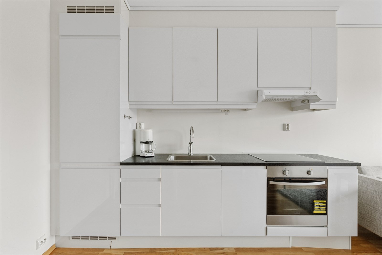 Lys kjøkkeninnredning med folierte skrog med slette fronter og laminert benkeplate. Galleribilde