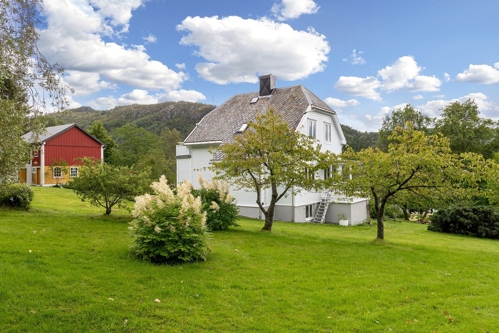 Pent oppparbeidet og beplantet hage med frukttrær og beplantninger Galleribilde