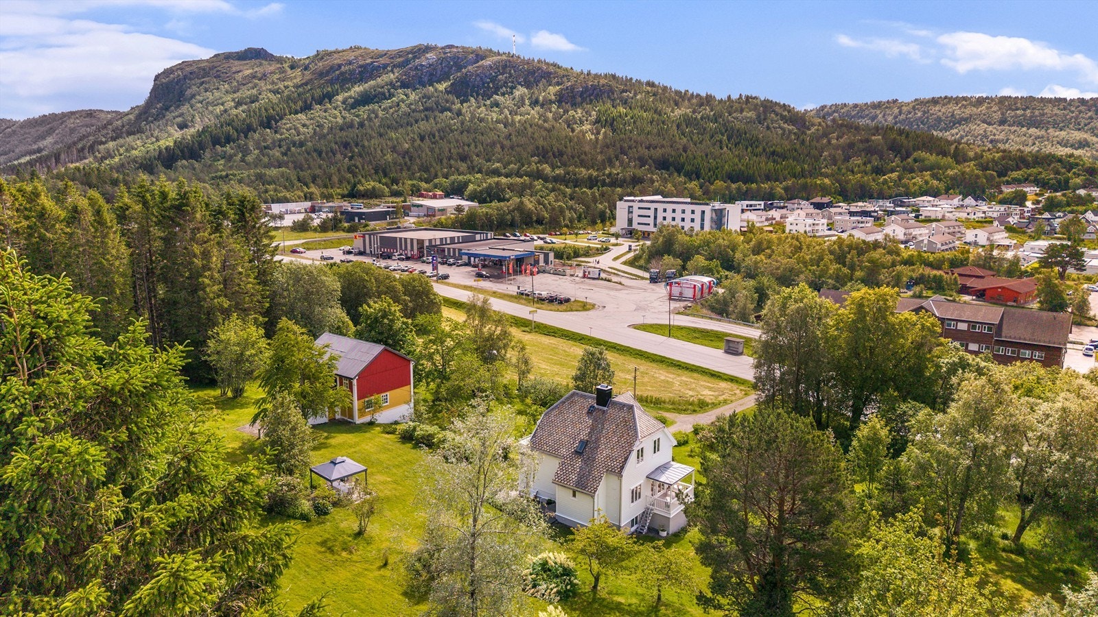 Dronebilde tatt fra nordvest mot Eidet, med dagligvarebutikker, bensinstatsjon og Eidet omsorgssenter. Rett bak butikkene til venstre i bildet ligger frisbeegolfbanen og den nye barne- og ungdomsskolen Eidet med idrettsanlegg Galleribilde