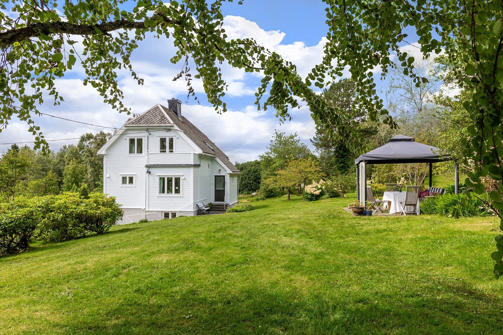 Fasade og hage øst for huset med solplass i hagen Galleribilde