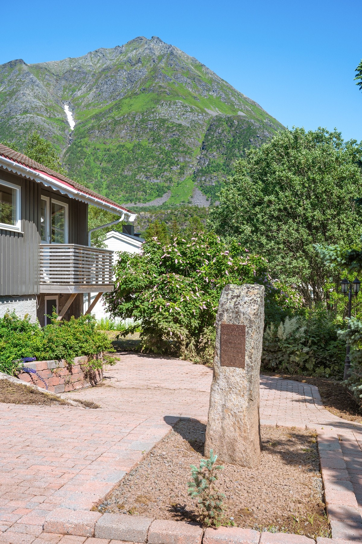 Stort og lettstelt uteområde med brostein, asfalt og flere solrike terrasser Galleribilde