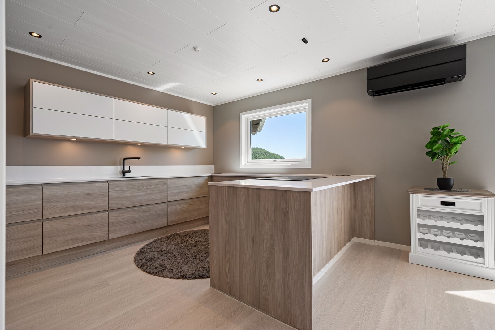 Kjøkkenøyen er perfekt som frokostplass med benkeplate som skaper "barløsning" på siden mot stuen Galleribilde