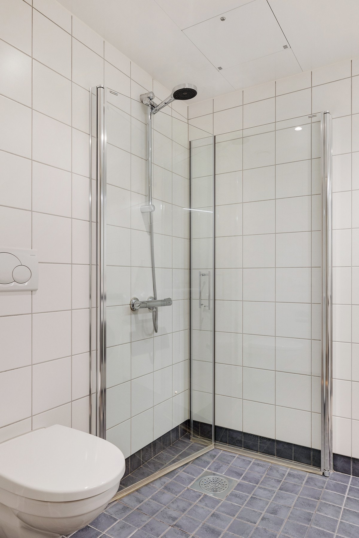 Badet har dusjhjørne med glassvegger og vegghengt toalett. Galleribilde