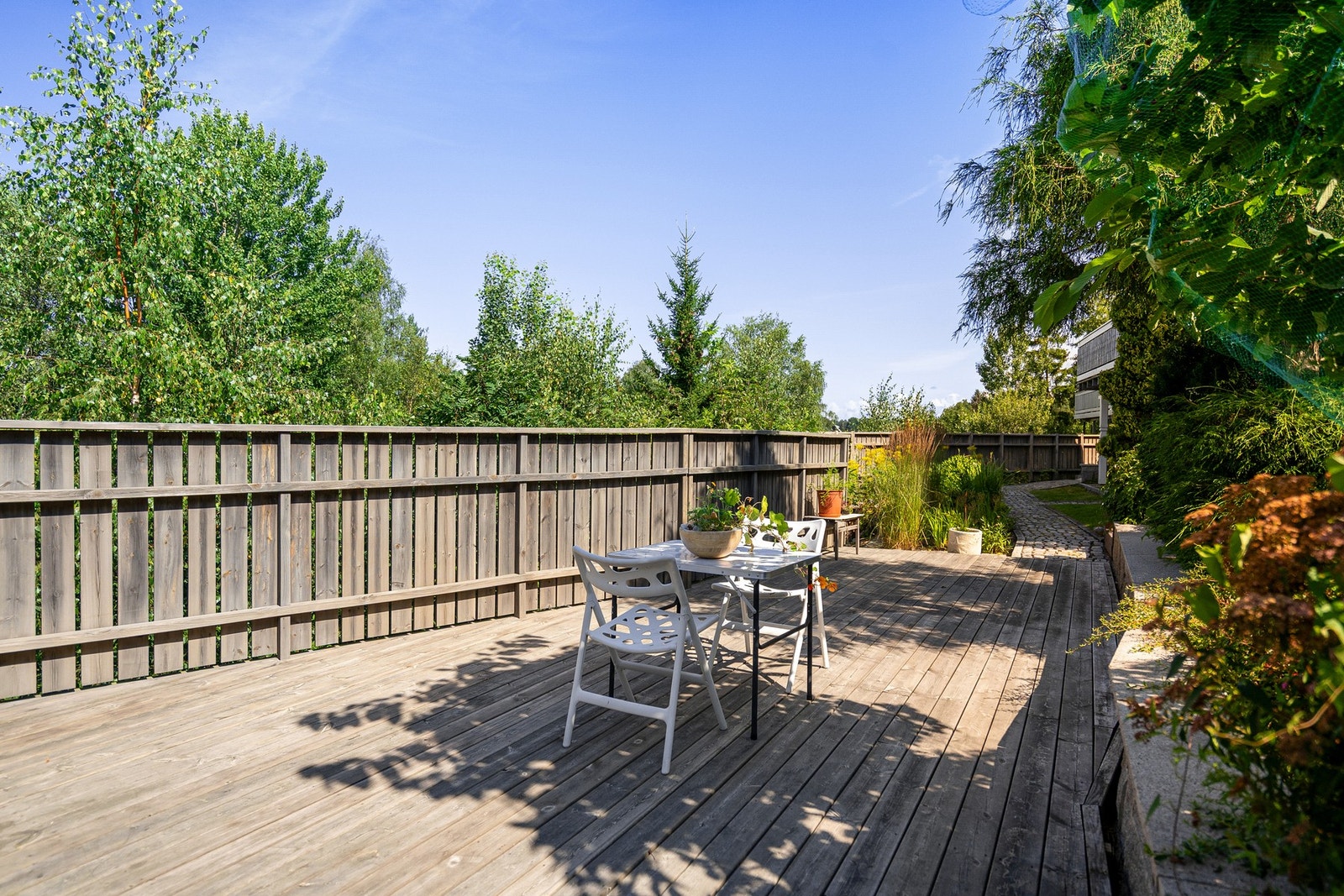 Den romslige verandaen gir rikelig med plass til både sittegruppe, grill og kanskje et par grønne krukker - et perfekt sted for lange sommerkvelder. Galleribilde