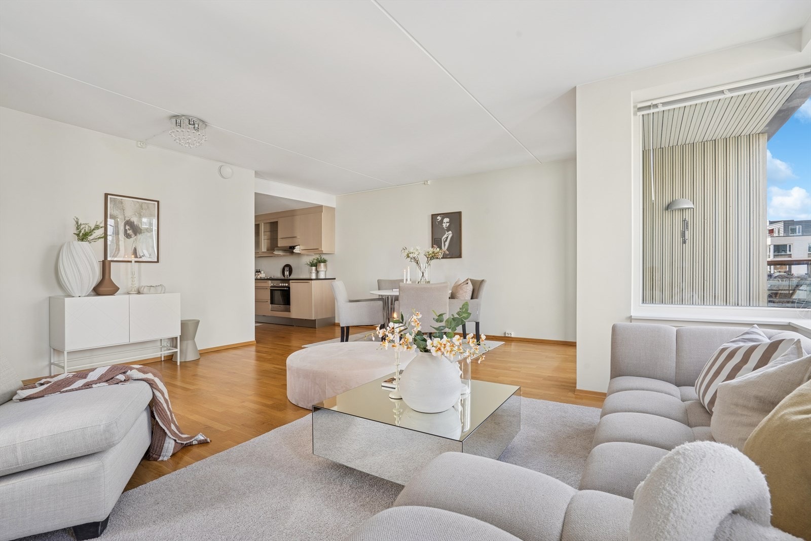 Den åpne løsningen mellom stue og kjøkken skaper en naturlig flyt i hjemmet, perfekt for både hverdagsliv og sosiale sammenkomster. Galleribilde