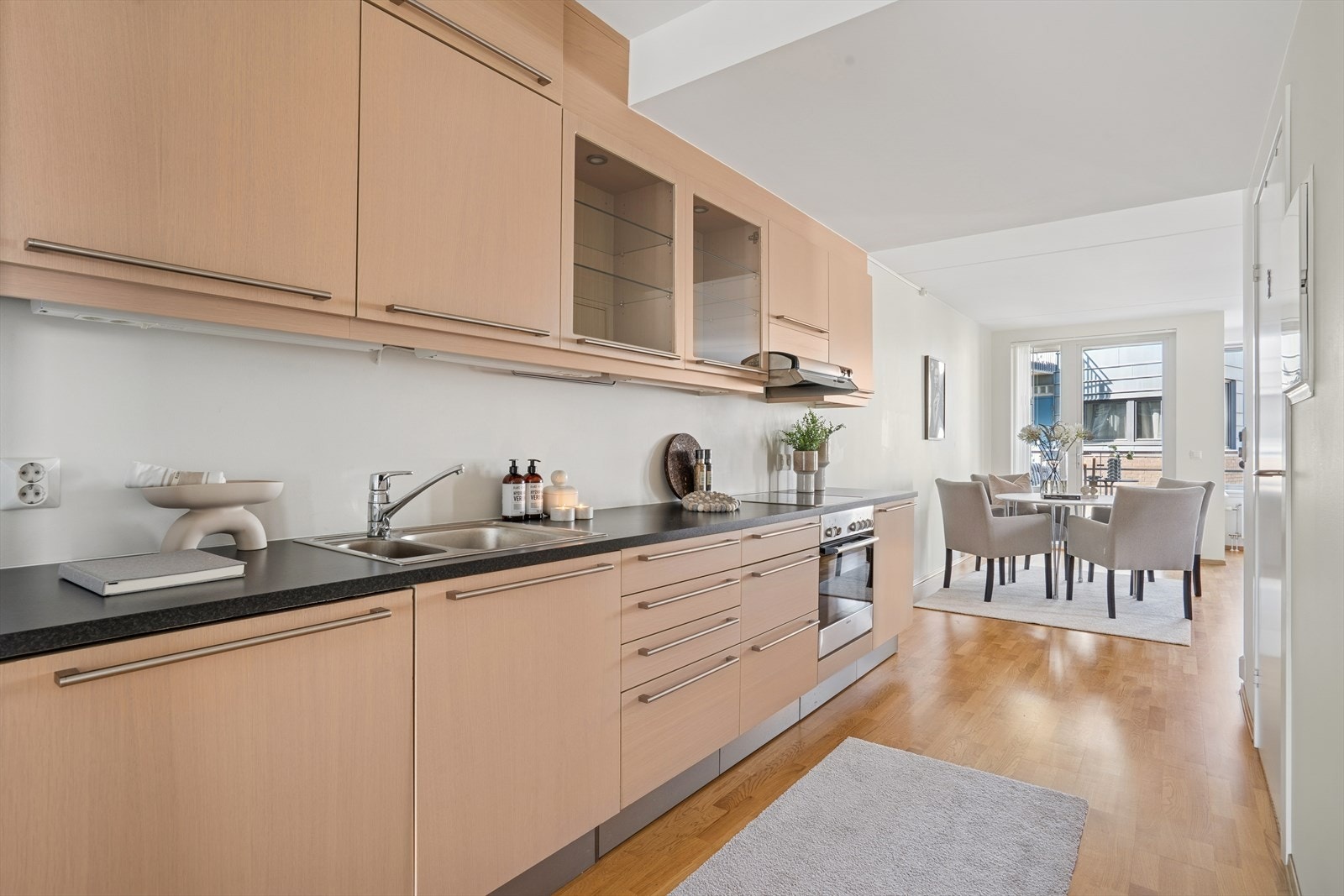 Kjøkkenet er praktisk utformet med folierte fronter, laminert benkeplate og integrerte hvitevarer som oppvaskmaskin, platetopp, stekeovn og ventilator. Galleribilde