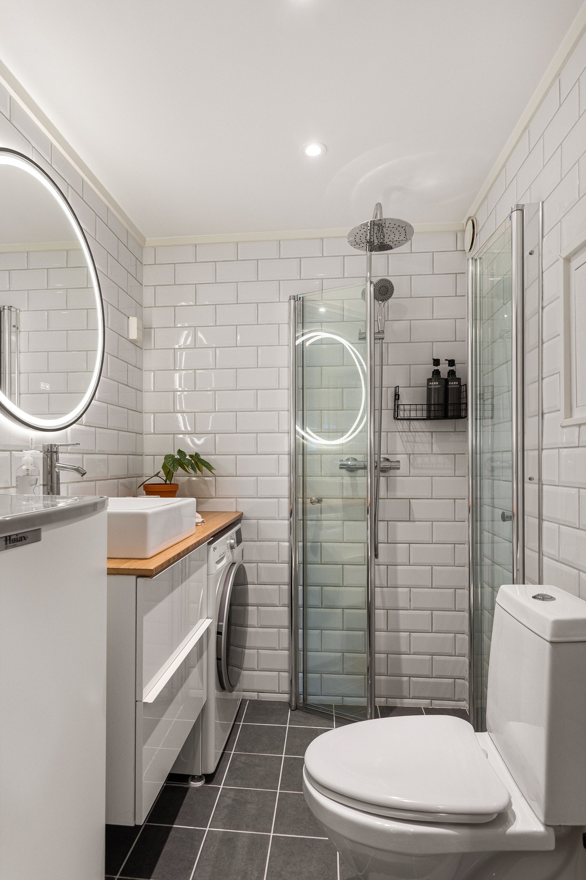 Boligens baderom er bygget opp med lyse fliser på vegger og grå fliser på gulv. Det er downlights i himling og varme i gulvet. Galleribilde