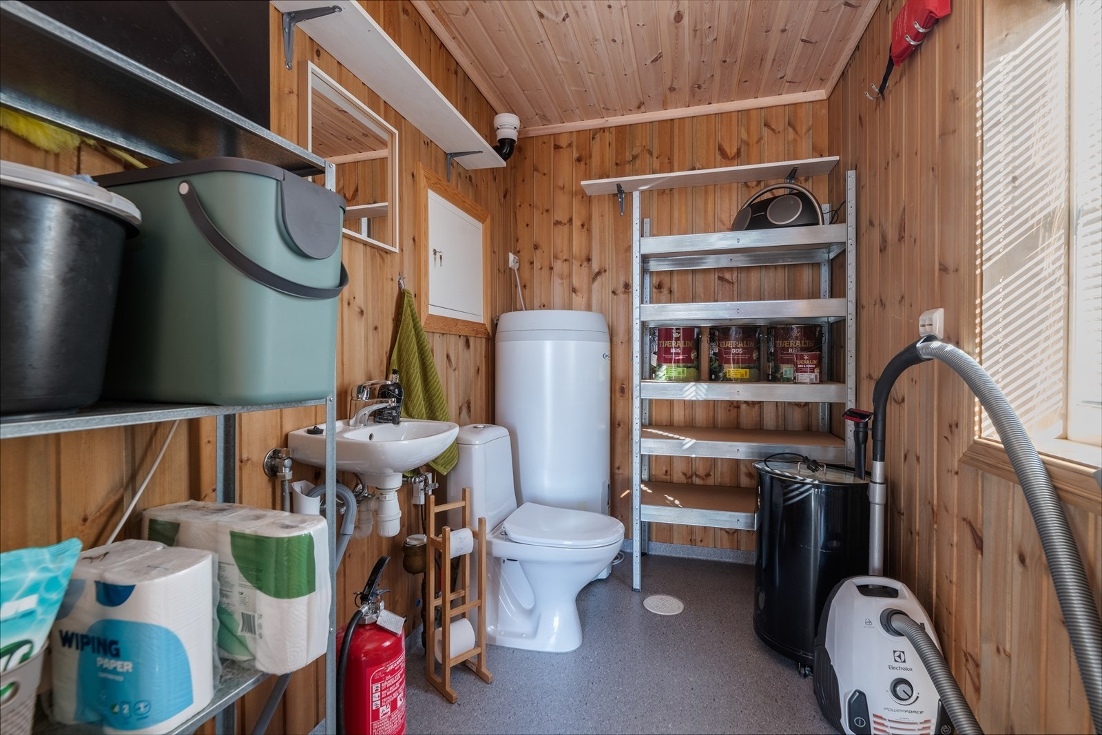Inntil vindfanget er det etablert eget vaskerom med opplegg for og plass til vaskemaskin. Her er det også satt inn vaskeservant og et ekstra toalett. Varmtvannstanken på ca. 200 liter er plassert her. For øvrig er det godt med oppbevaringsplass. Galleribilde
