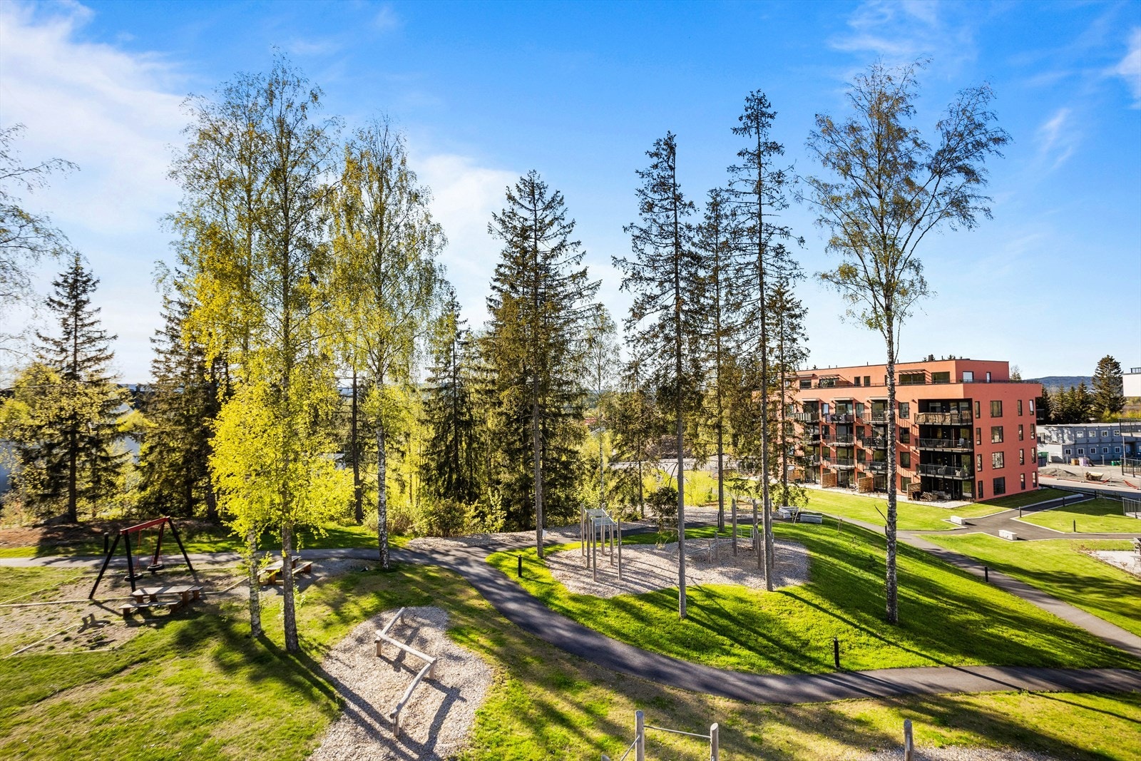 Fellesarealet er pent opparbeidet med et hyggelig grøntareal mellom blokkene. Galleribilde