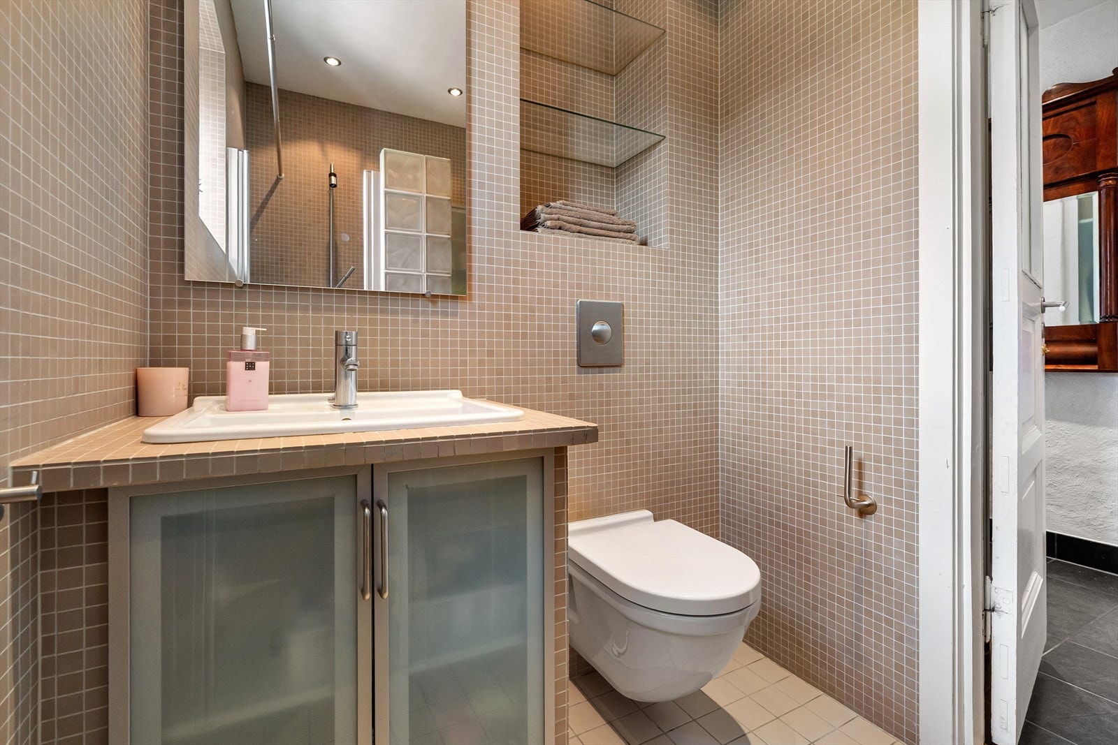 Rommet er utstyrt med naturlig avtrekk, dusjnisje, veggmontert toalett og servantskap med ettgreps blandebatteri fra Mora. Galleribilde