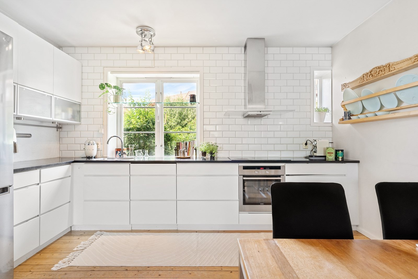 Pent og moderne kjøkken med innredning fra Kvik. Her er det godt med lagringsplass i både over- og underskap, samt rikelig med benkeplass på en solid benkeplate i stein. Galleribilde