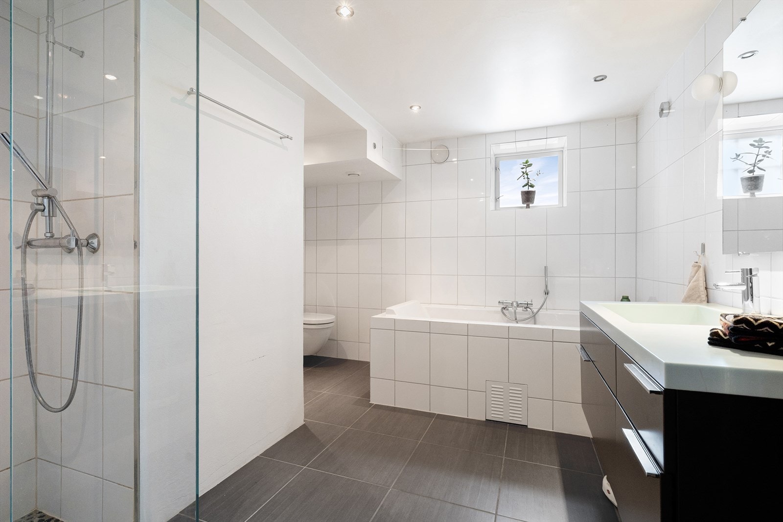 Stort og tidløst bad med både badekar og dusjnisje med innfellbare glassdører. Galleribilde