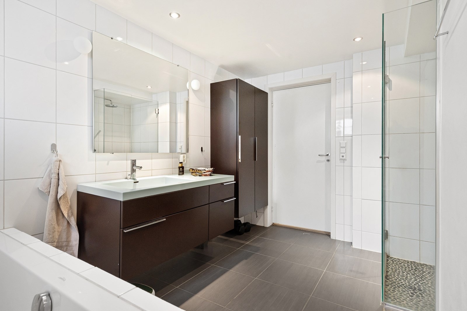 Rommet har flislagt gulv med gulvvarme, samt flis og malte overflater på veggene. Badet er utstyrt med naturlig avtrekk. Galleribilde