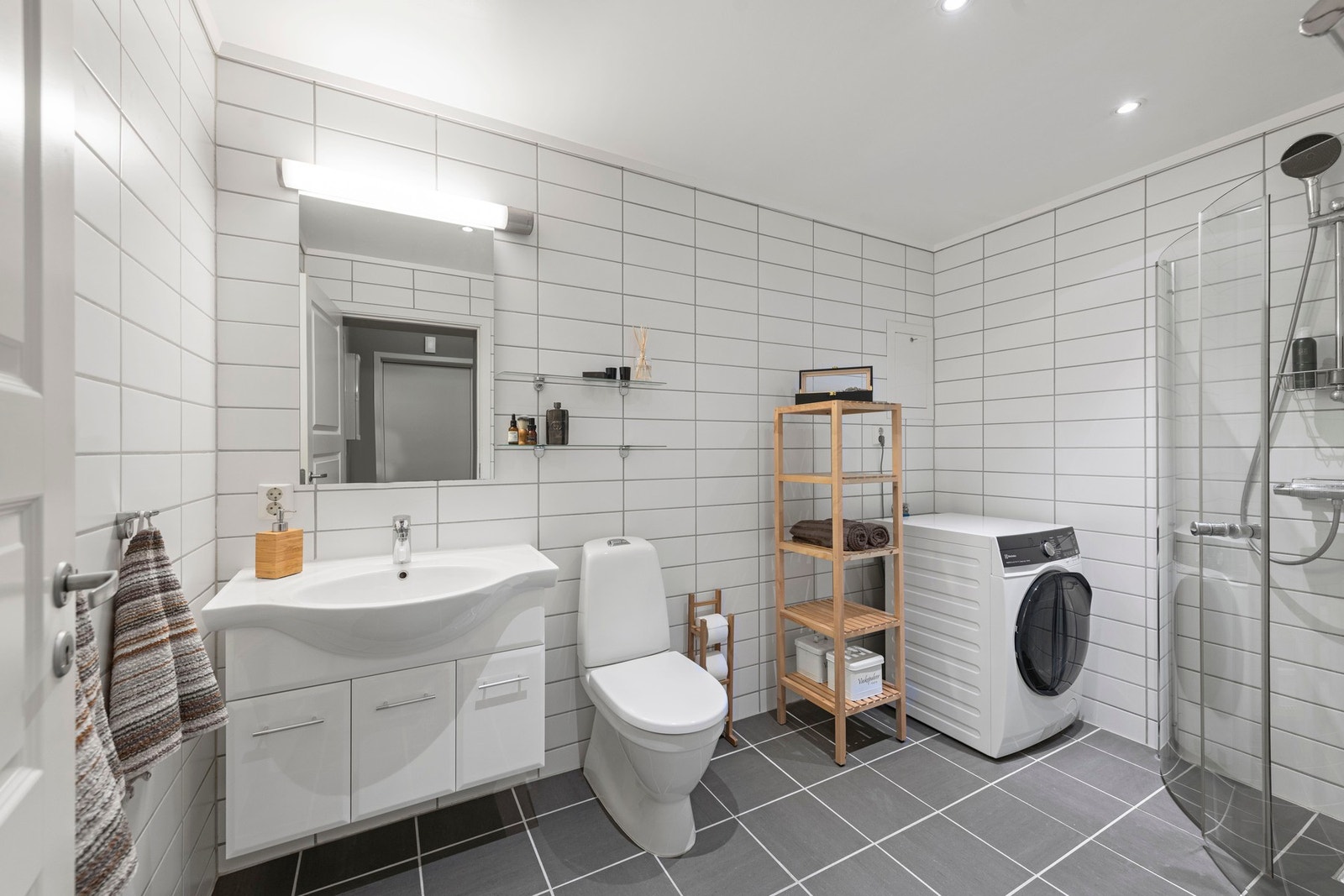 Badet har fliser på gulv med varmekabler. Flislagte vegger og malte slette plater med downlights i innvendig tak. Galleribilde