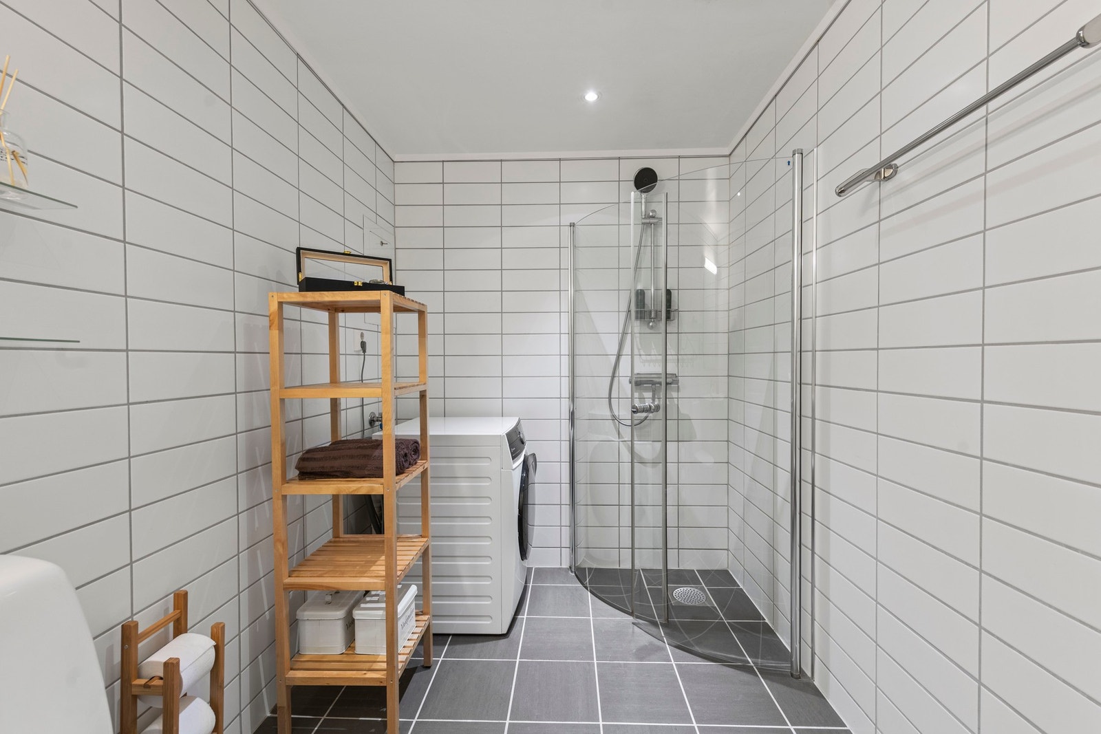 Innredet med servantinnredning, dusjhjørne, opplegg for vaskemaskin og wc. Galleribilde