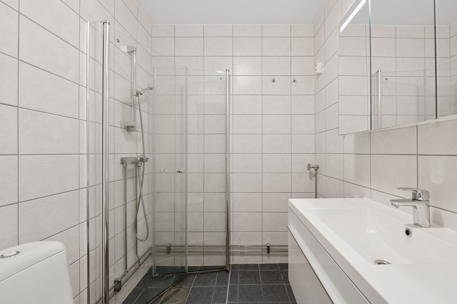 Flott flislagt bad. Innredningen består av klosett, servant med innredning og dusjhjørne. Bad er oppgardert i regi av borettslaget. Galleribilde