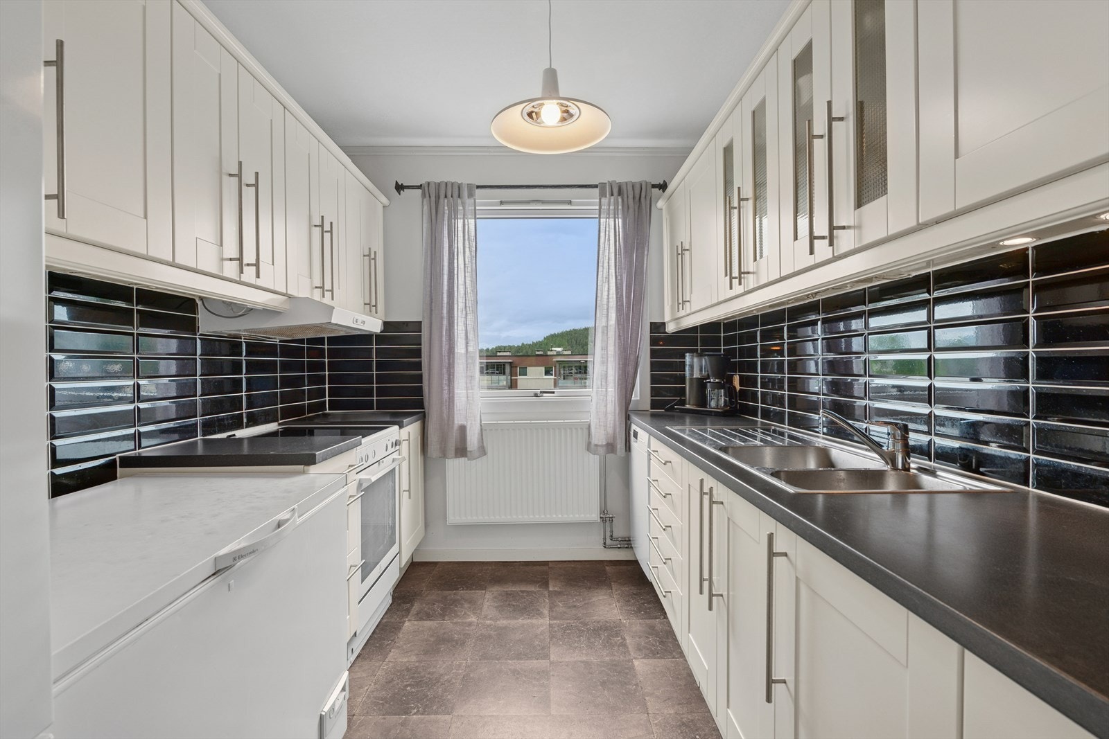 Kjøkkenet er lyst med profilerte fronter, benkeplate av laminat. Her er det rikelig med skap- og benkeplass. Det er kjøkkenventilator med kullfilter. Galleribilde