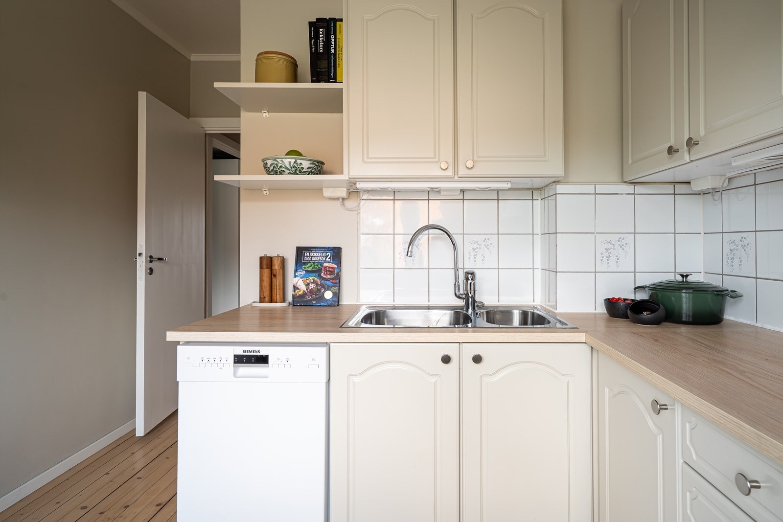 Profilerte fronter malt i 2024 med ny laminatbenkeplate og nedfelt kum i rustfritt stål. Galleribilde