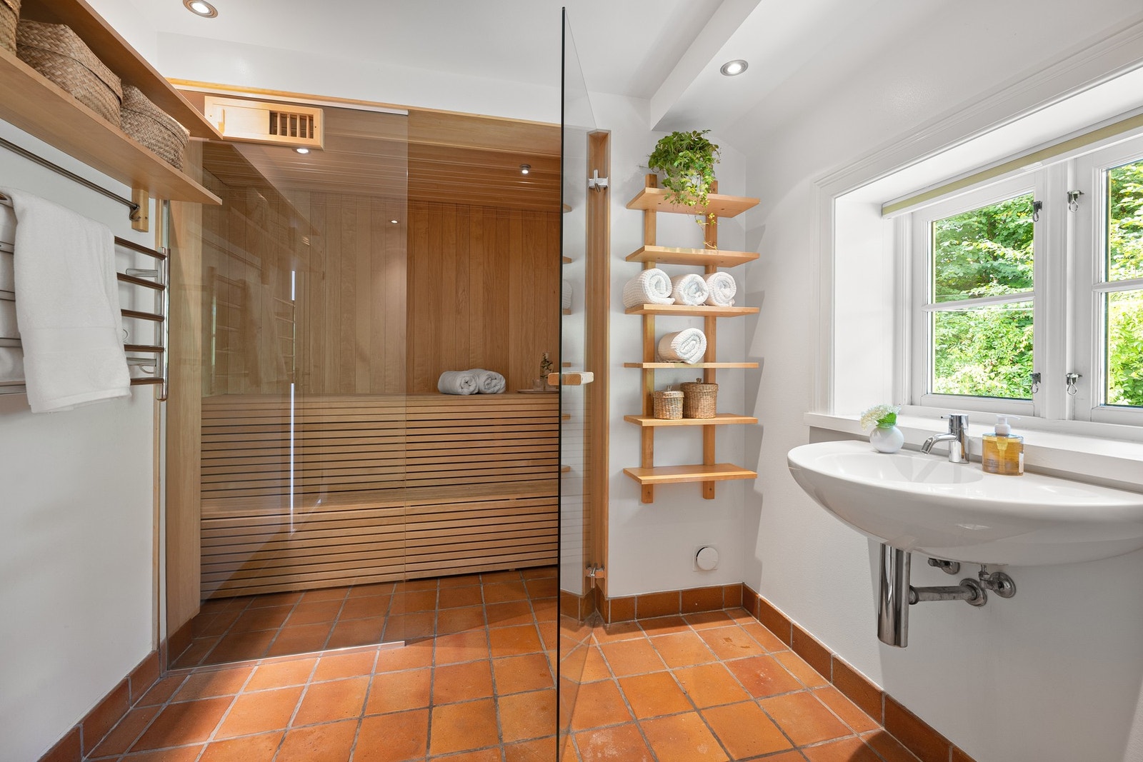 Dette badet har en lys og tiltalende atmosfære, og byr på det lille ekstra i form av en innbydende badstue med glassvegg og -dør. Galleribilde