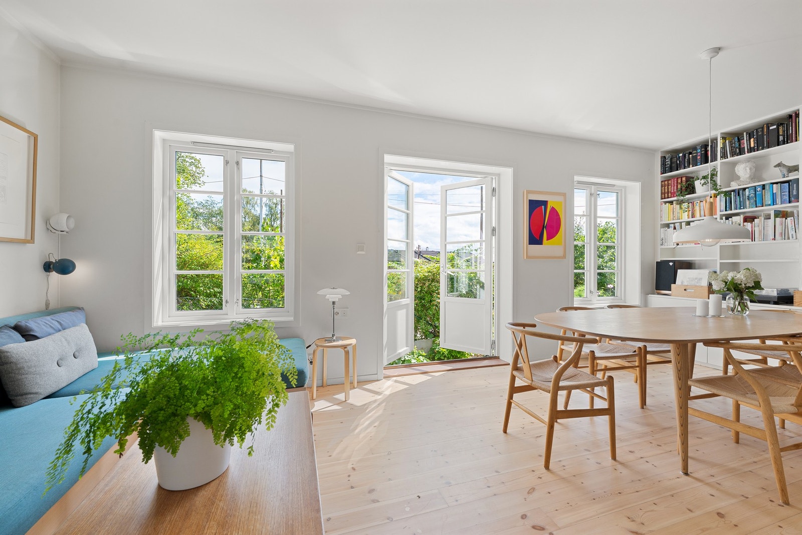 Stuen fremstår som et lyst og innbydende oppholdsrom med store vindusflater som slipper inn rikelig med naturlig lys og gir flott utsyn mot den frodige hagen. Galleribilde