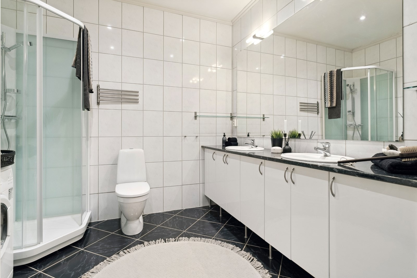 Baderommet har dusjkabinett, gulvmontert toalett, innredning med servant samt opplegg for vaskemaskin. Galleribilde