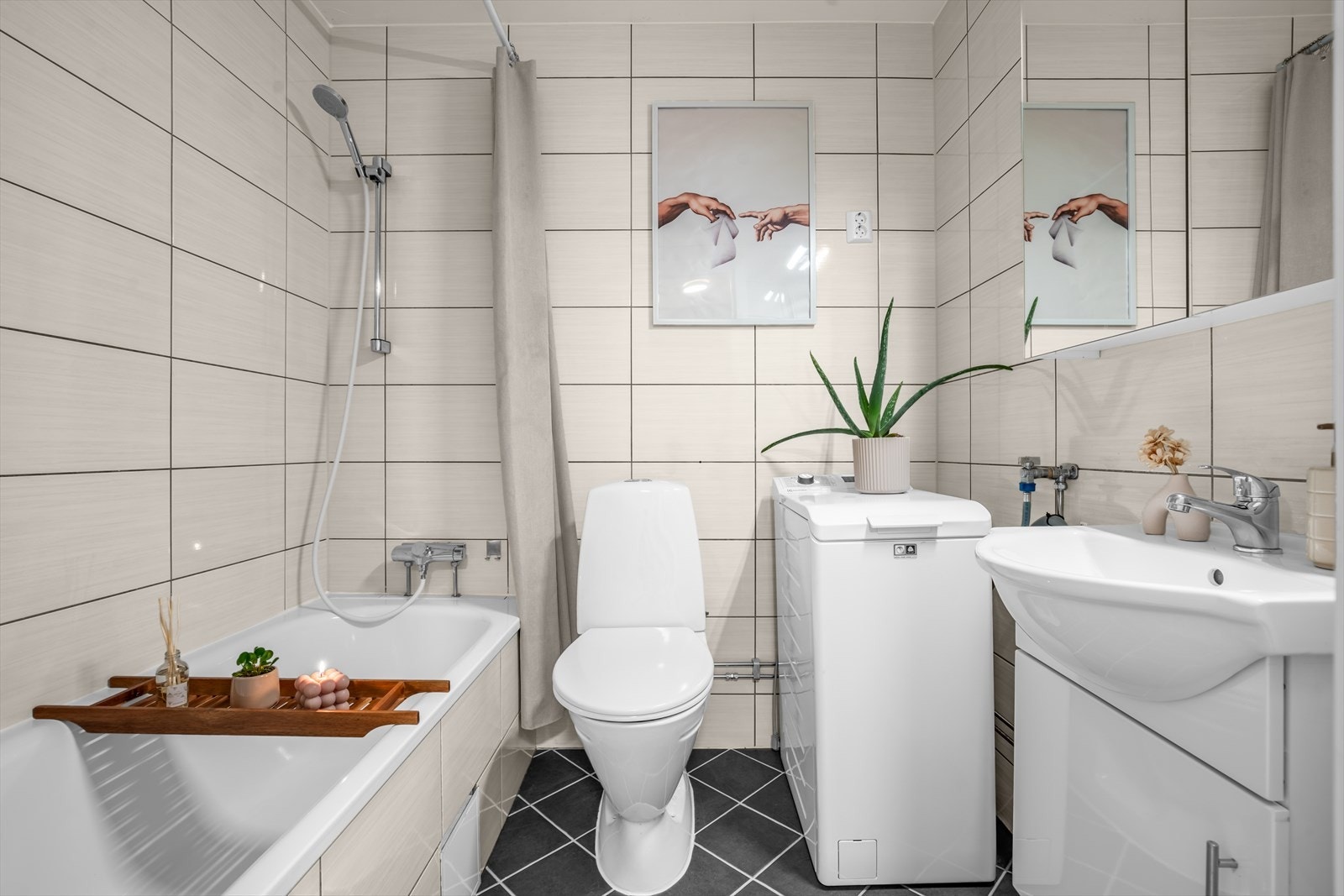Helfliset baderom innredet med toalett, badekar, servant m/baderomsinnredning og opplegg for vaskemaskin. Galleribilde