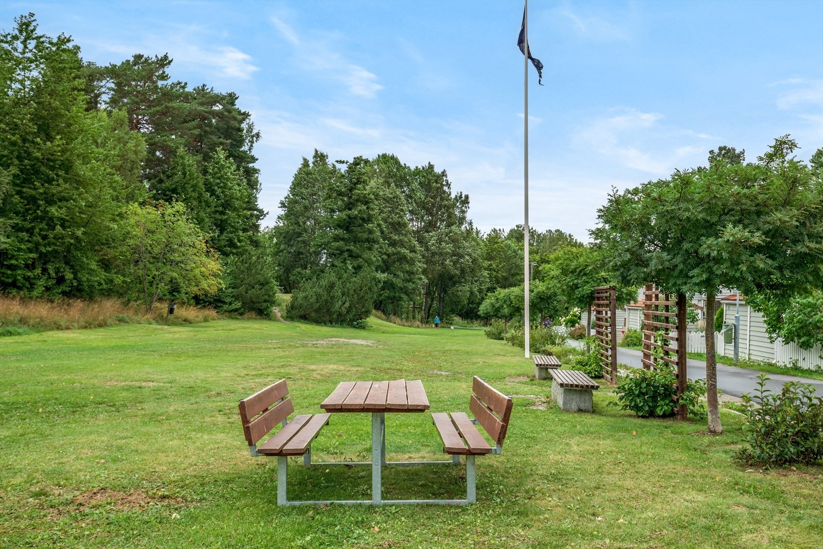 Pent opparbeidet felles tomt for borettslaget med asfalterte gang/stikkveier, lekeplasser, sittegrupper, grøntarealer, trær og beplantning. Galleribilde