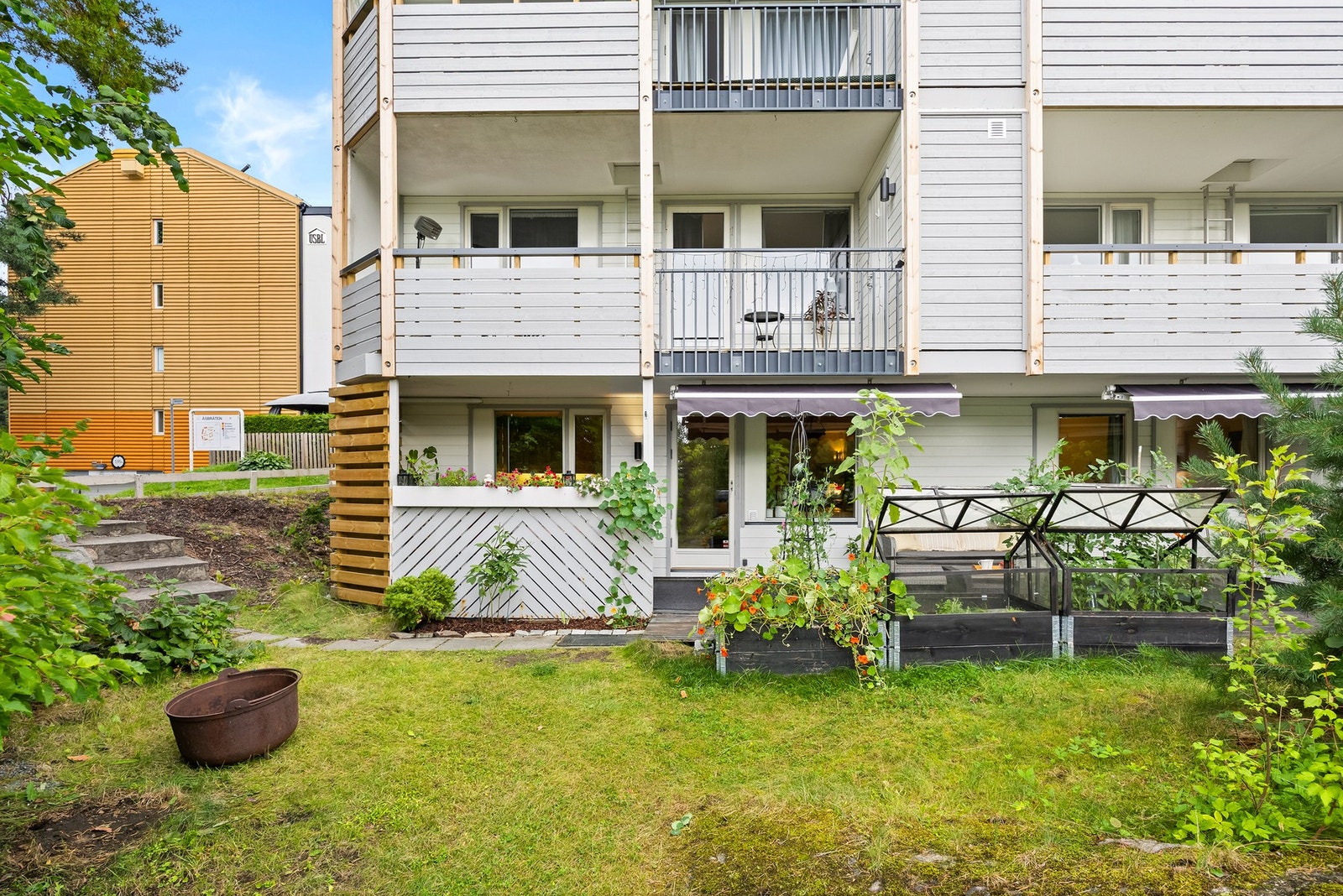 Det er både stikkontakt og lysarmatur montert på veggen, slik at terrassen enkelt kan benyttes også på kveldstid. To markiser med nye duker fra 2025 gir god solskjerming. Galleribilde