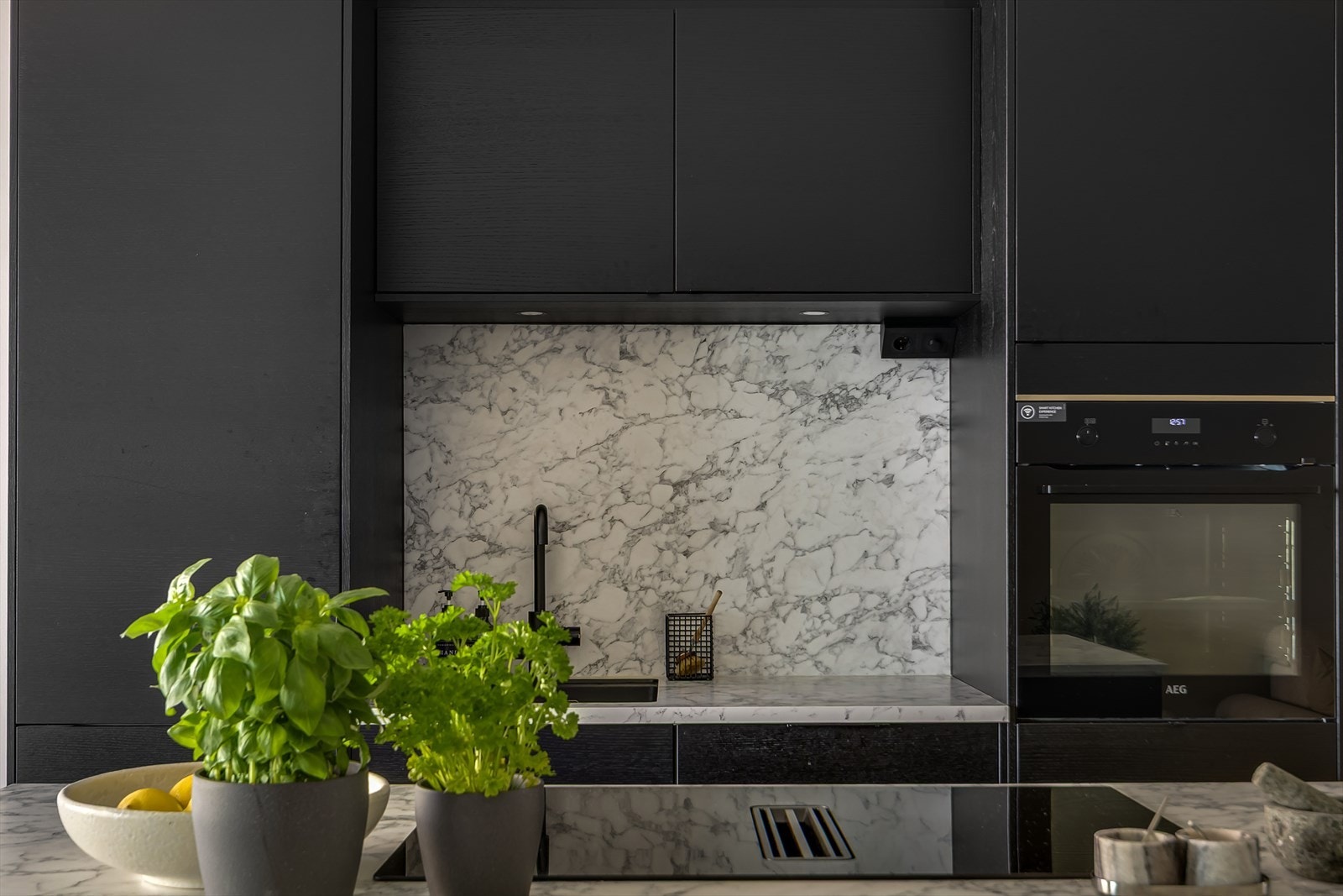 Her er alt av hvitevarer integrerte i kjøkkenet, og kullfiltervifte er integrert i platetopp Galleribilde