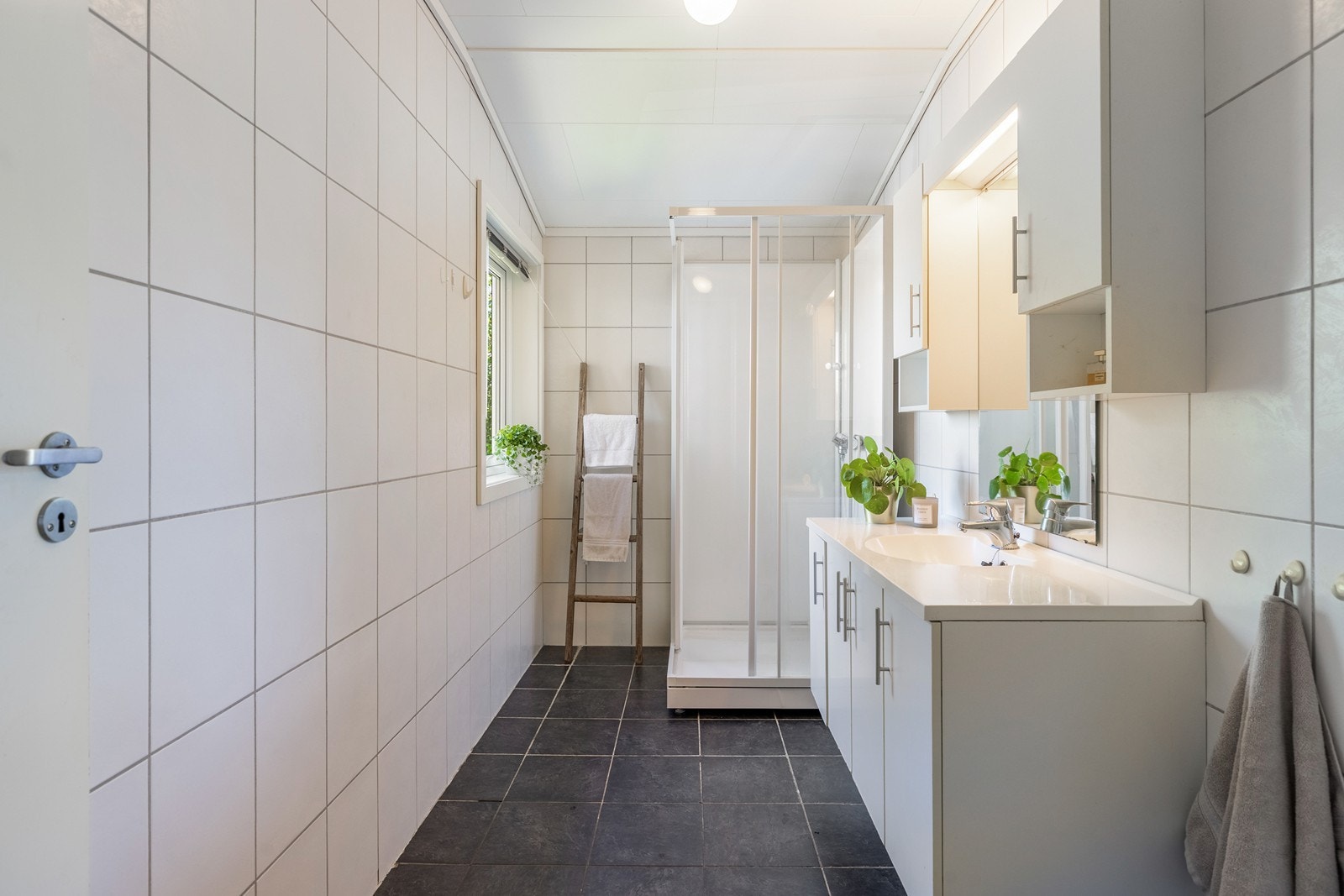 Bad innredet med dusjkabinett, wc, servant og speil. Galleribilde