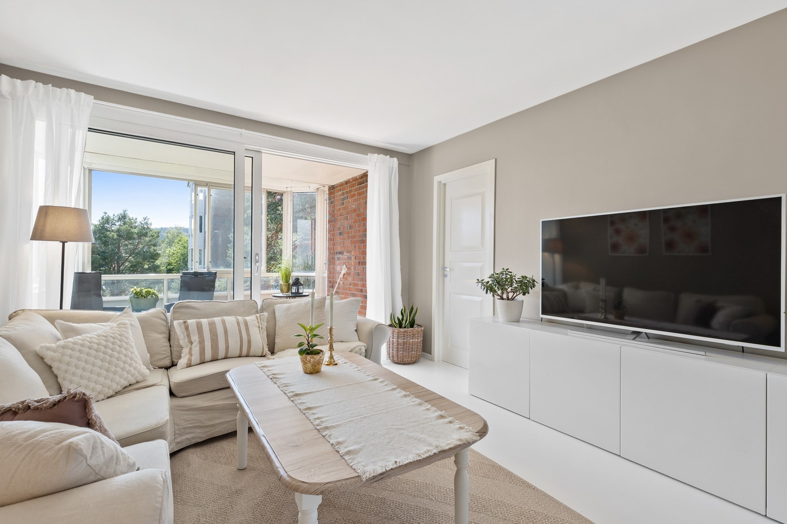 Fra stuen er det utgang til boligens innglassede balkong. Galleribilde