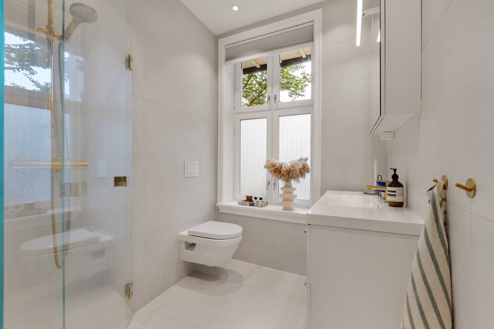 Det er lyse fliser fra gulv til tak. Galleribilde