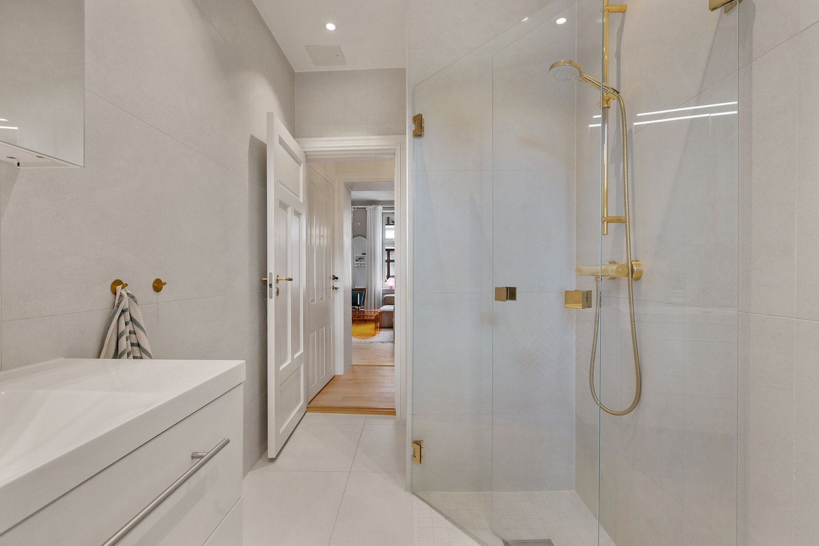 Badet har moderne innredning med messingdetaljer Galleribilde