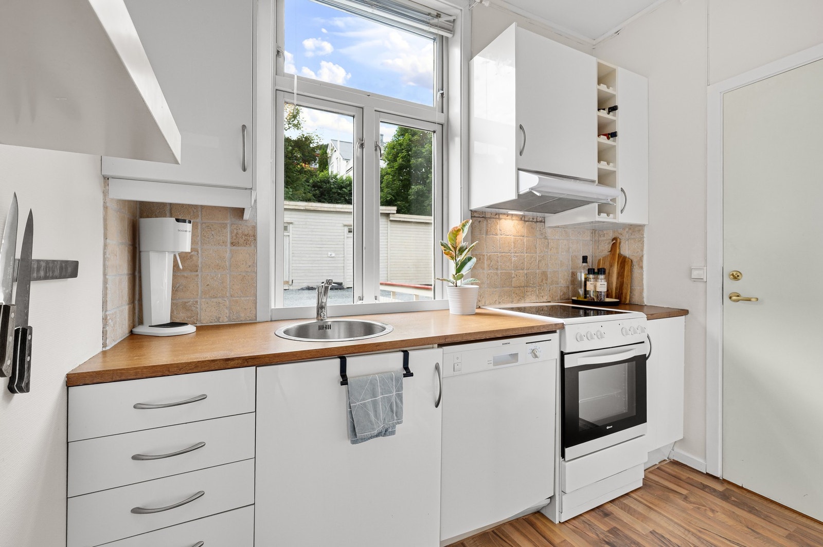 Kjøkkenet har lyse overflater. Galleribilde