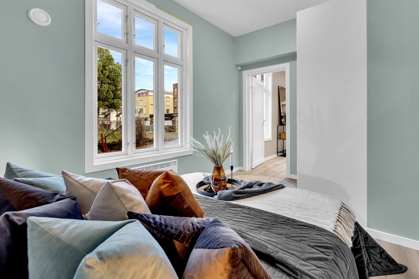 Soverommet har store vindusflater og vegger er malt i en dus og behagelig grønn tone. Galleribilde