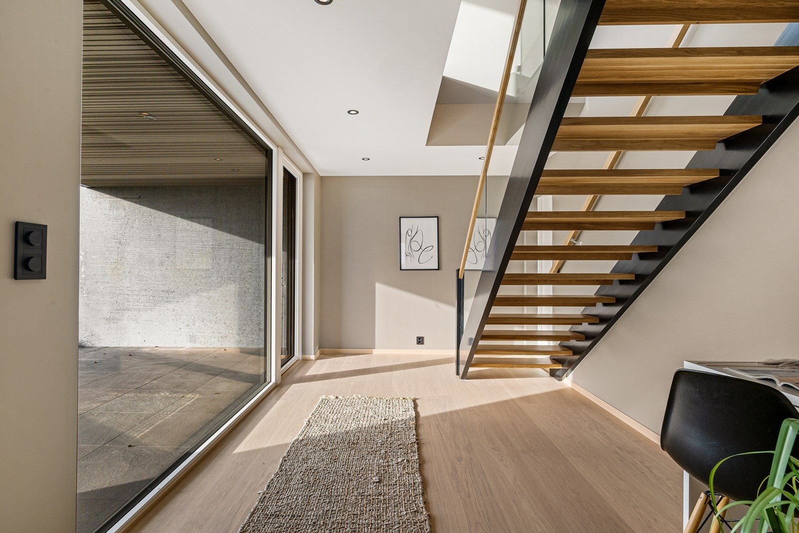 Trappen ned fra 1. etg. og gangen med utgang til overbygget markterrasse Galleribilde