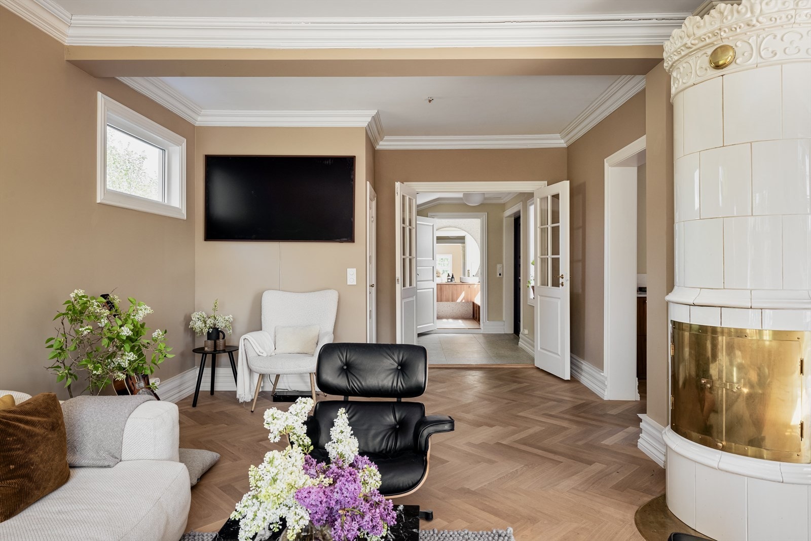 Stuen er innredet med flott kakkelovn og murt peis som sørger for en hyggelig stemning og god oppvarming til boligens hovedetasje Galleribilde