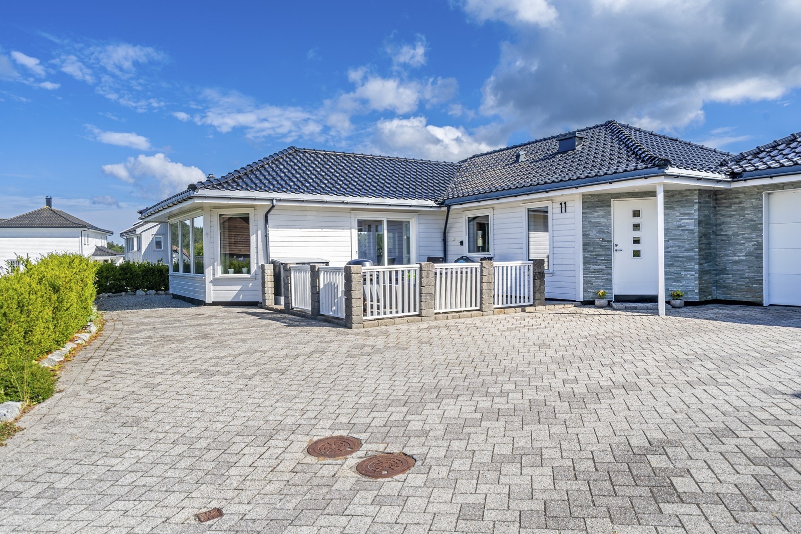 Fasaden har flott skiferforblending i inngangsparti og på garasjen mot vest Galleribilde