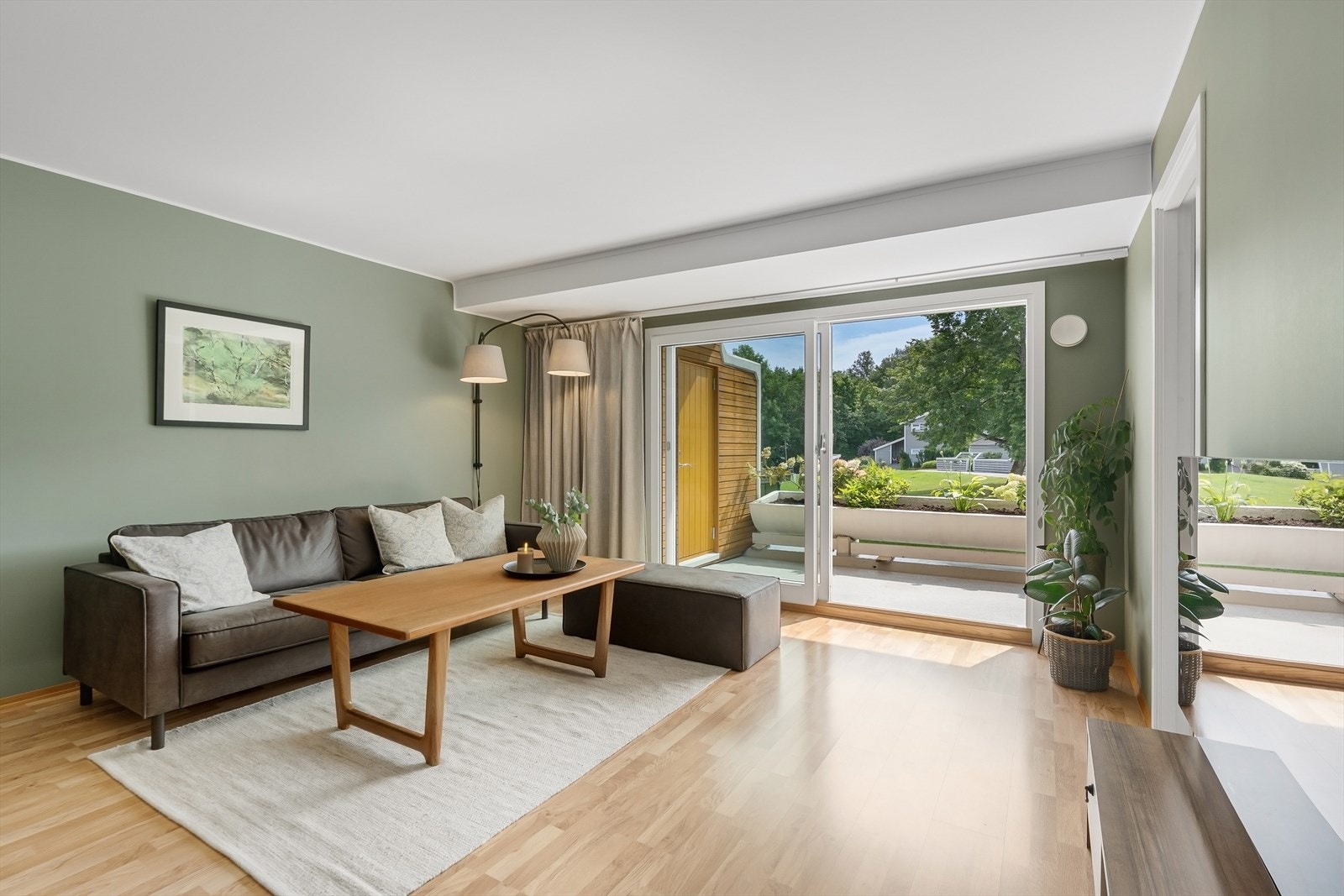 De store glassskyvedørene ut til balkongen gir godt med daglys og gjør dette til en lys og behagelig stue. Galleribilde