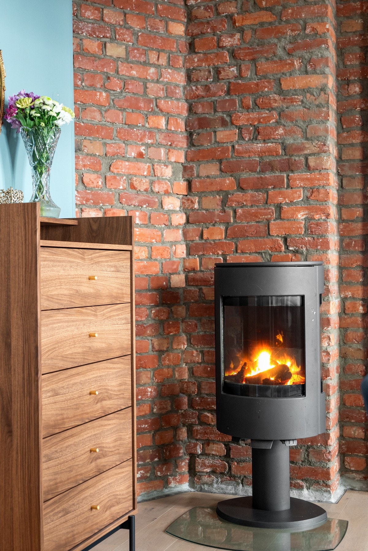 I det ene hjørnet står en delikat bevart teglsteinspipe med vedovn - både dekorativ og funksjonell. Galleribilde