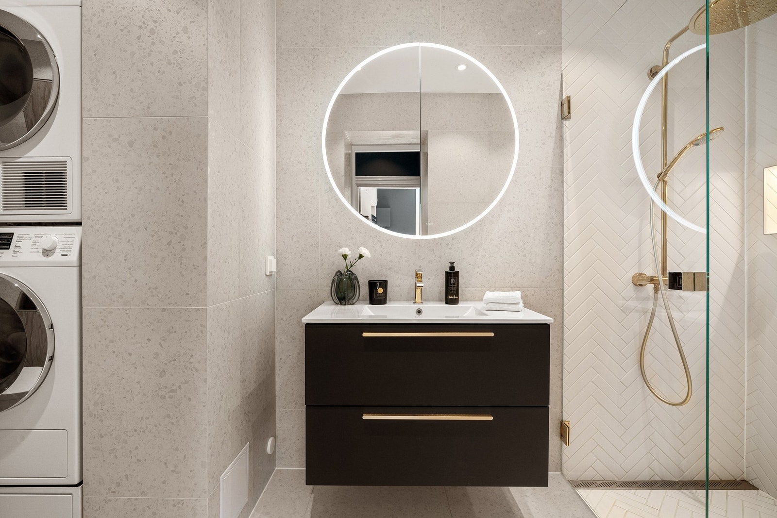 Badet har stilren baderomsinnredning med heldekkende servant og praktiske skuffer for oppbevaring, samt vegghengt speil med integrert belysning. Galleribilde