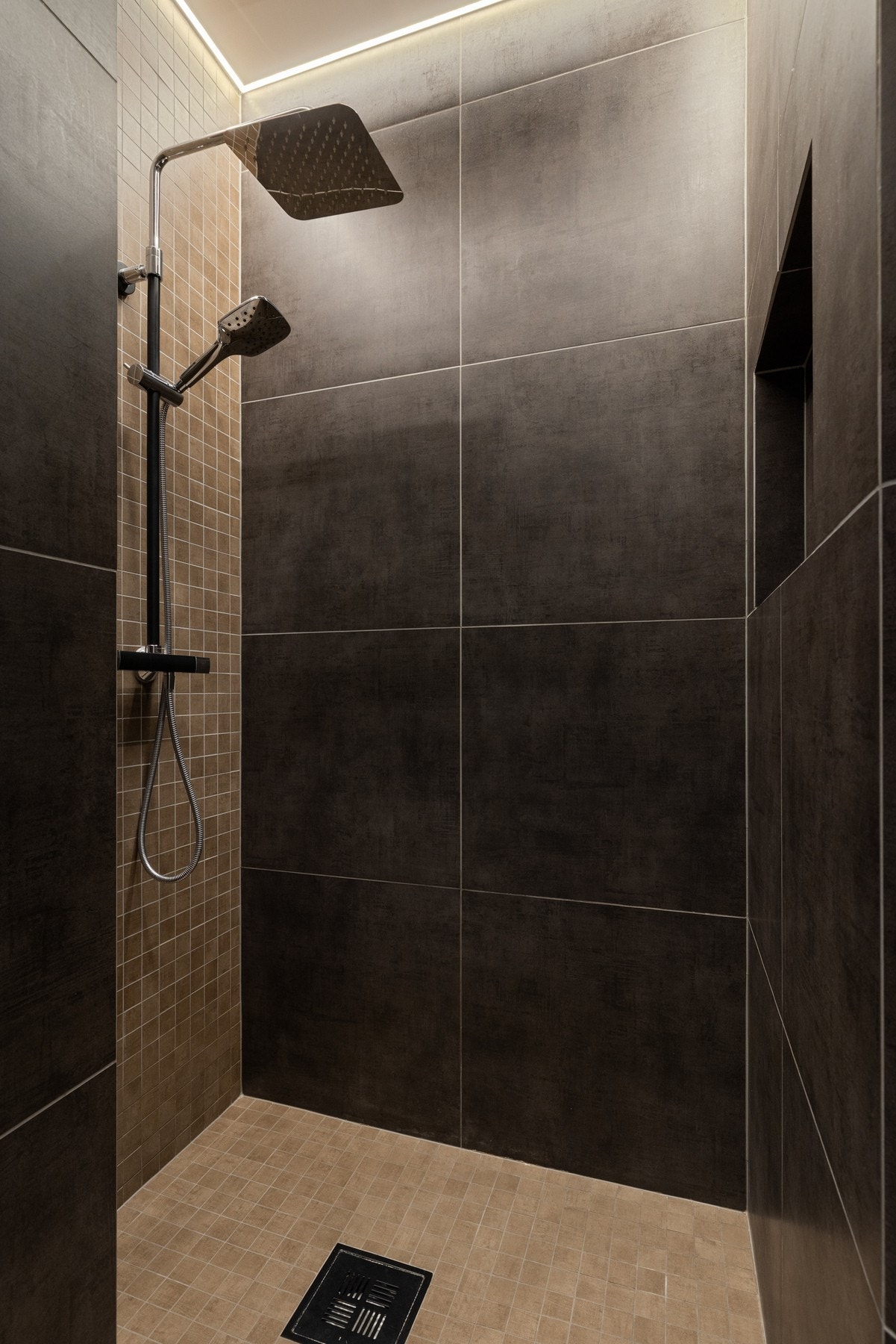 Romslig dusjhjørne med innfelt nisje. Armatur med waterfall- og hånddusj. Galleribilde