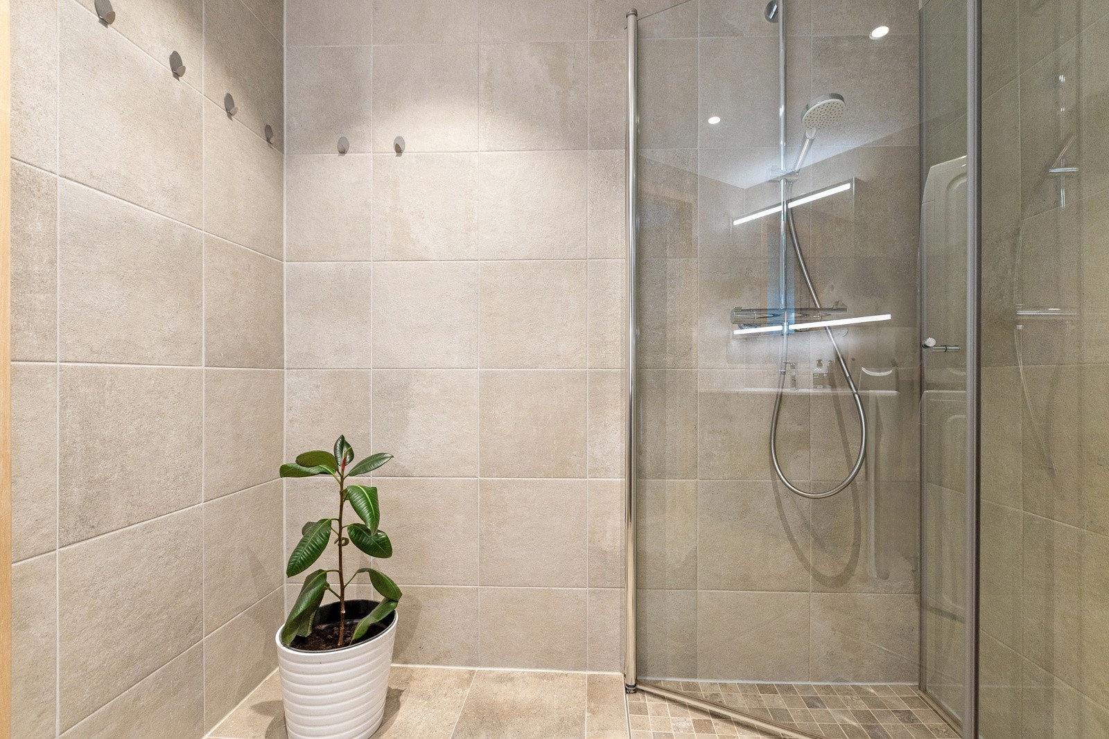 Dusjhjørne med inn-/utadslående glassdører. Galleribilde