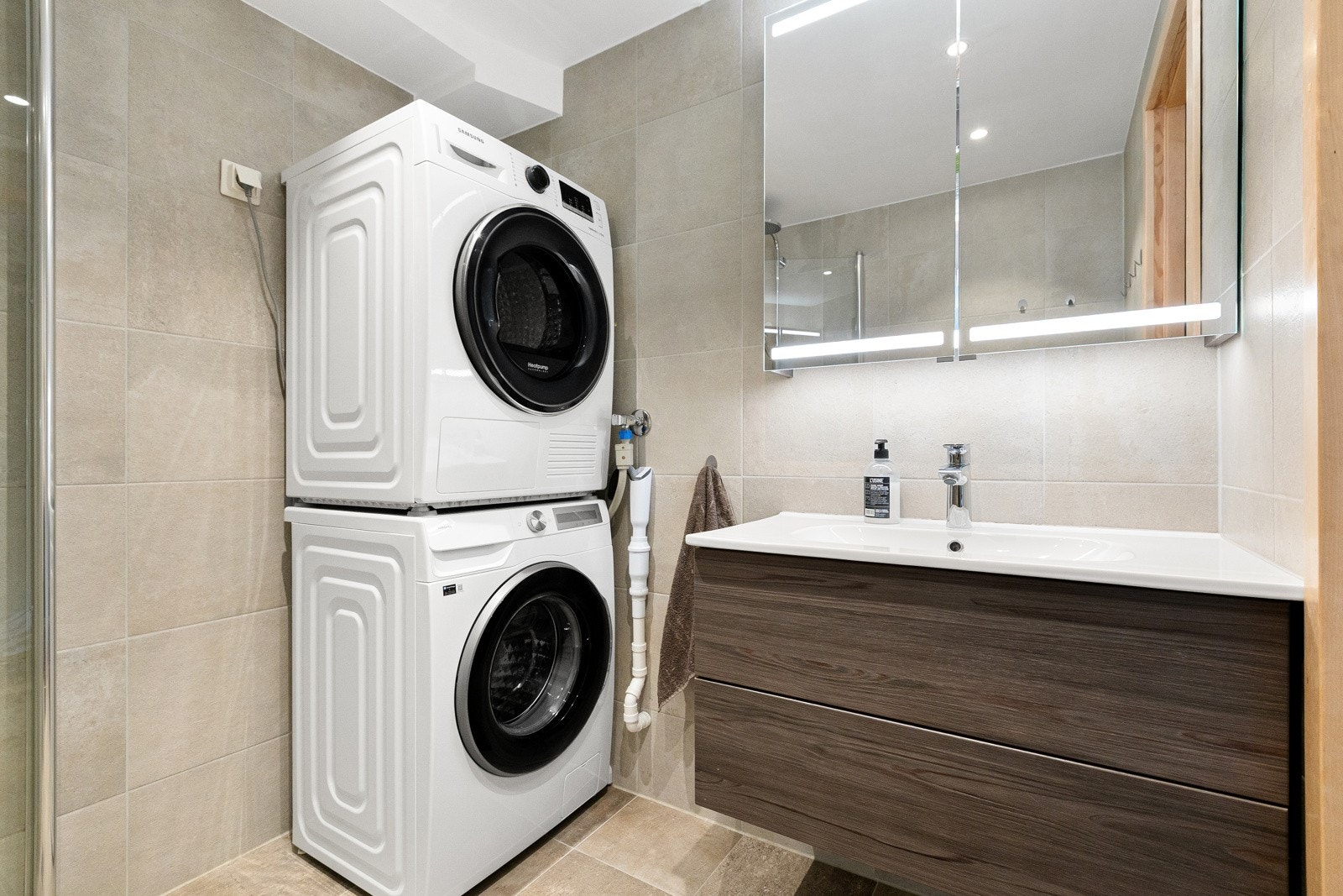 Badet har servant med underskap, speil med belysning og opplegg for vaskemaskin. Galleribilde