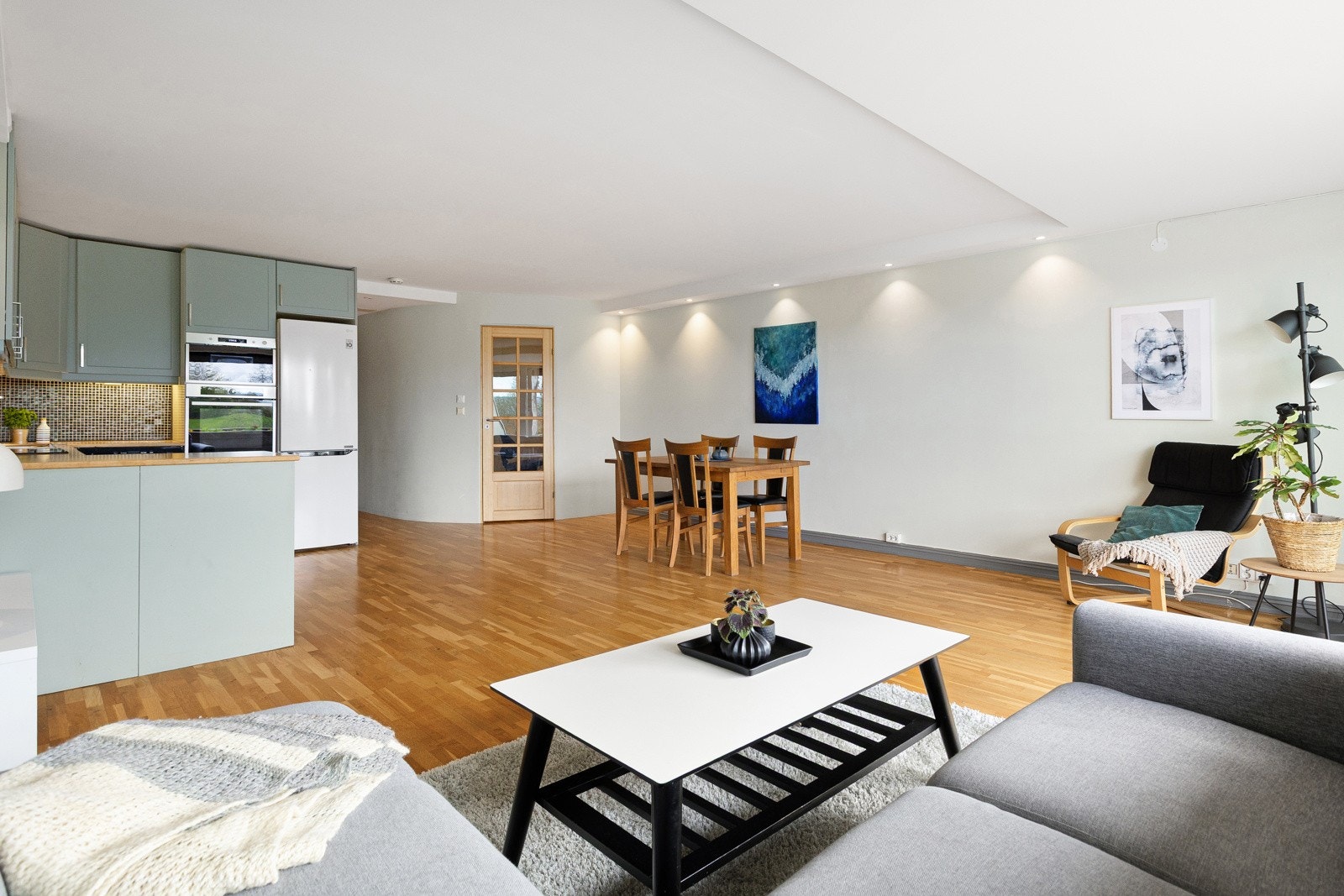 Rommet har god plass til både sofagruppe og spisebord, og fungerer som et naturlig samlingspunkt i boligen. Galleribilde