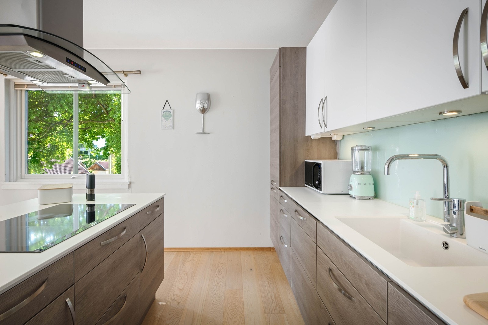 Rene hvite benkeflater og belysning under overskap på kjøkken Galleribilde